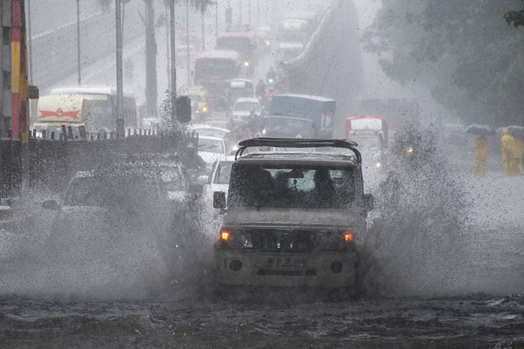 印度孟買因暴雨積水嚴重 民眾駕車“衝浪”前行